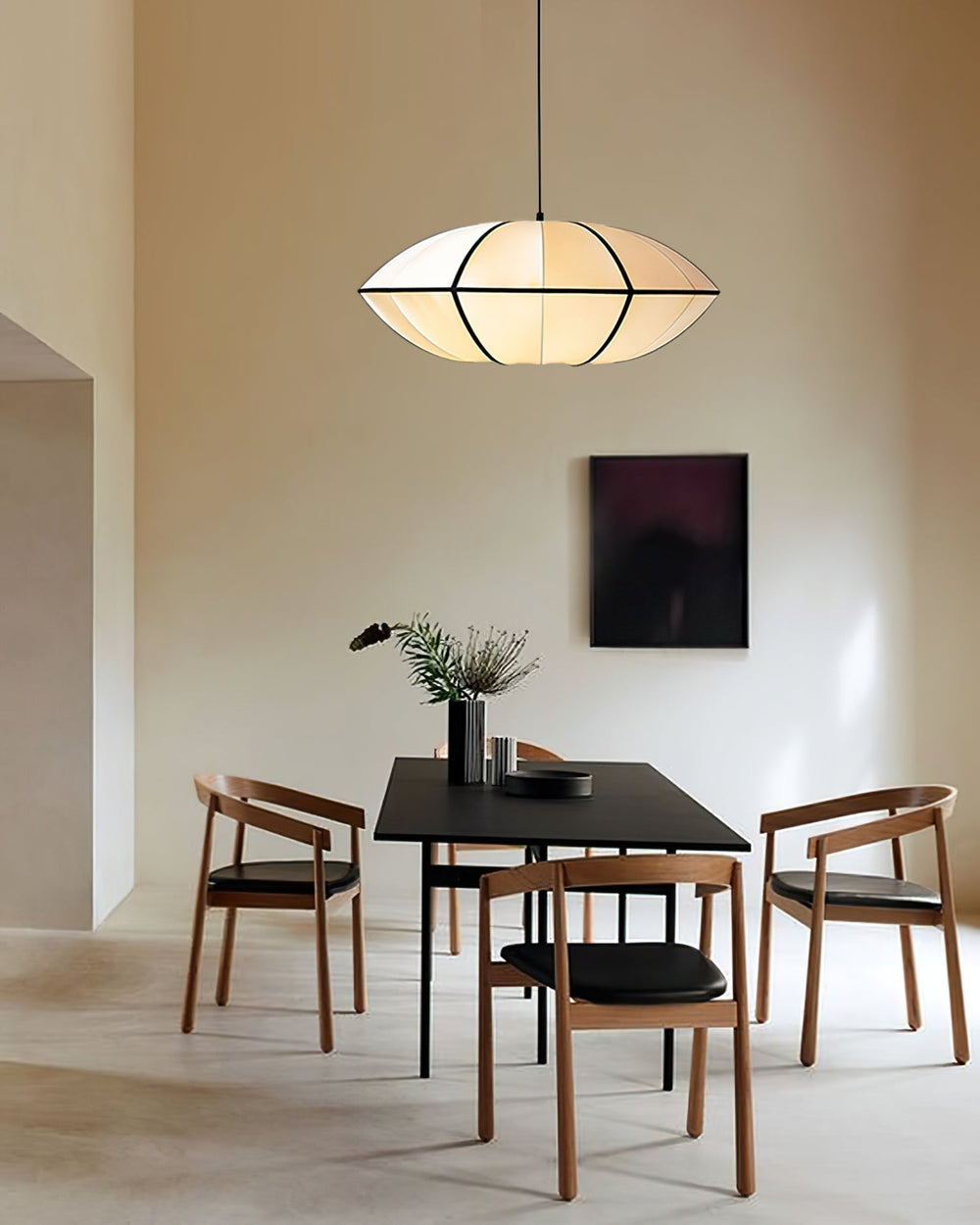 Lanterra lantern pendant above a dark dining table with wooden chairs