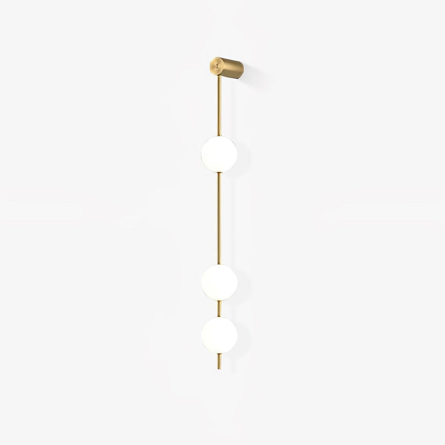 Wall lamp with a vertical row of white ball shades on a slim gold-toned rod, unlit, on a white background.