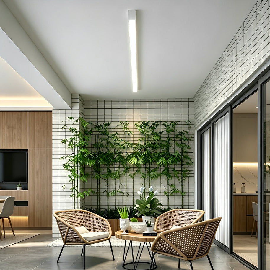 Slim linear LED ceiling light with a white body, fitted across a ceiling above a seating area.