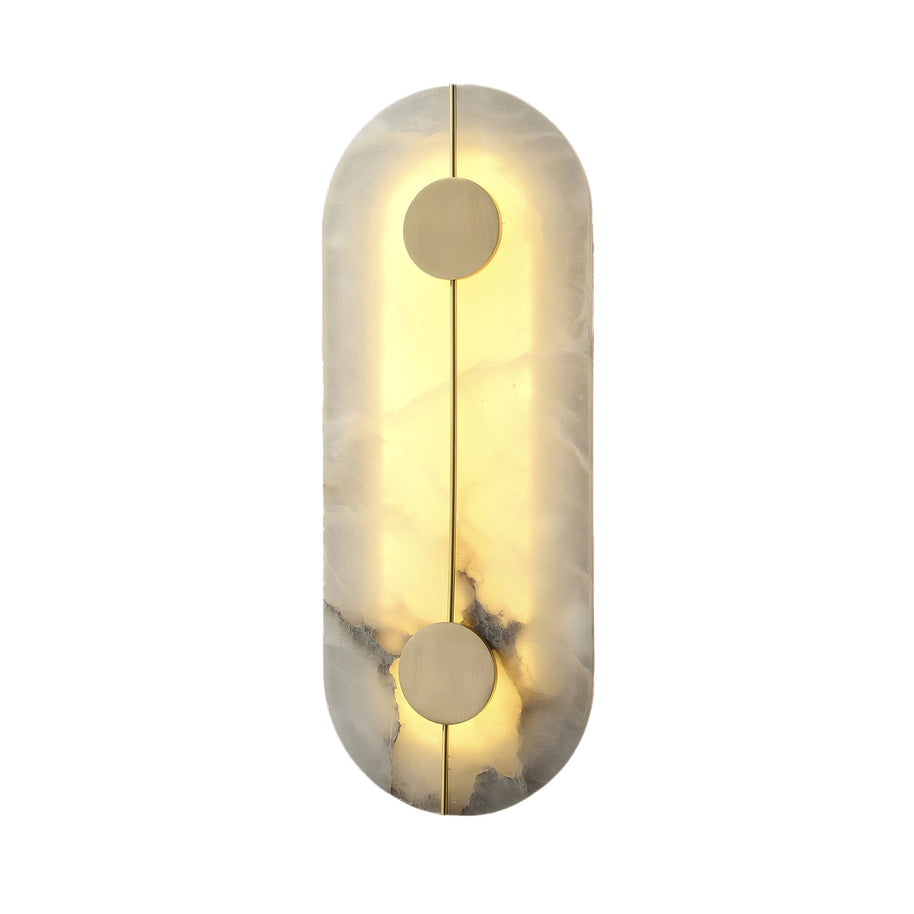 Wall light with a tall rounded alabaster panel, a slim brass rod and two brass discs lit on a white background.