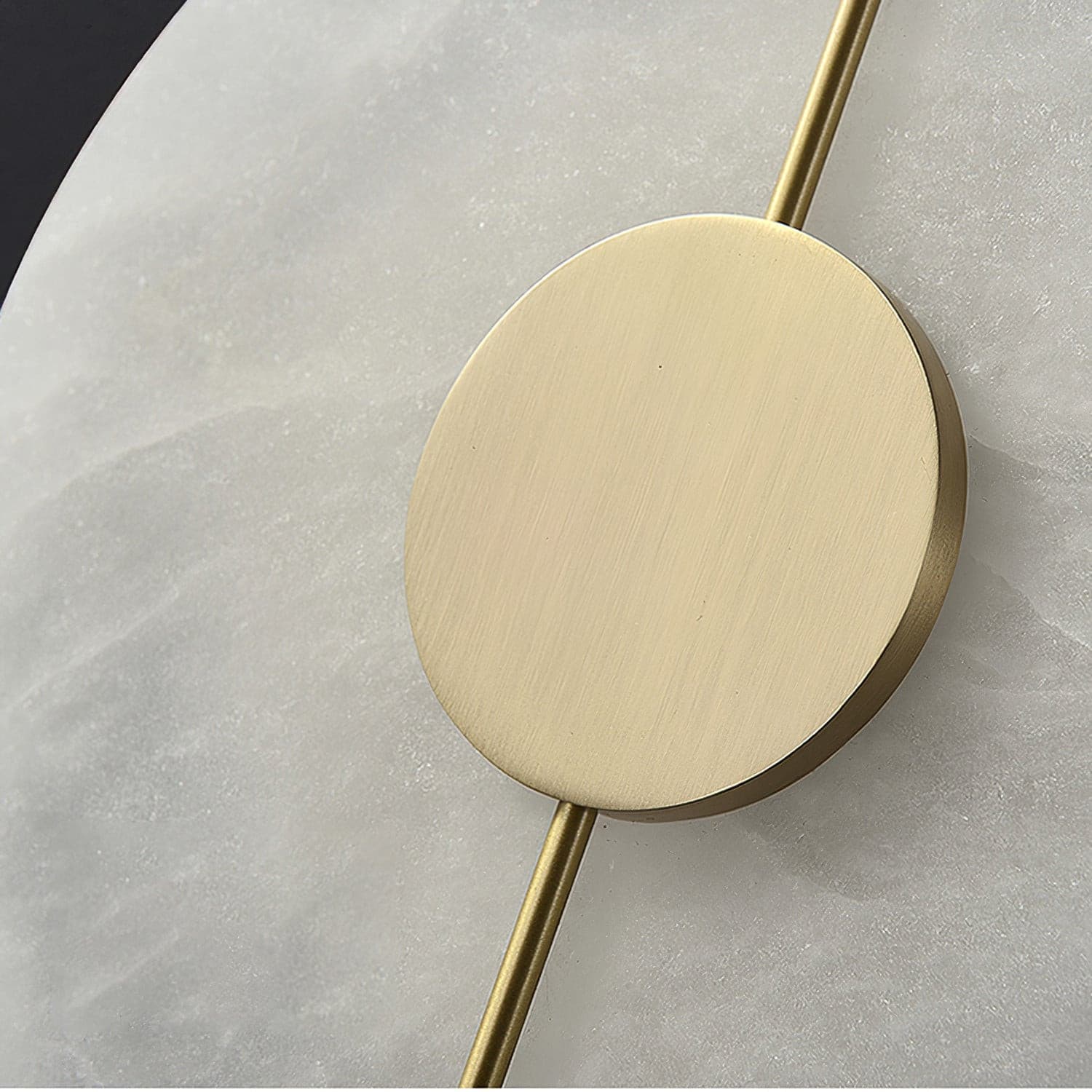 Close view of the brass centre disc and rod against unlit alabaster.