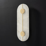 Wall light with a tall rounded alabaster panel, a slim brass rod and two brass discs, unlit, on a dark background.