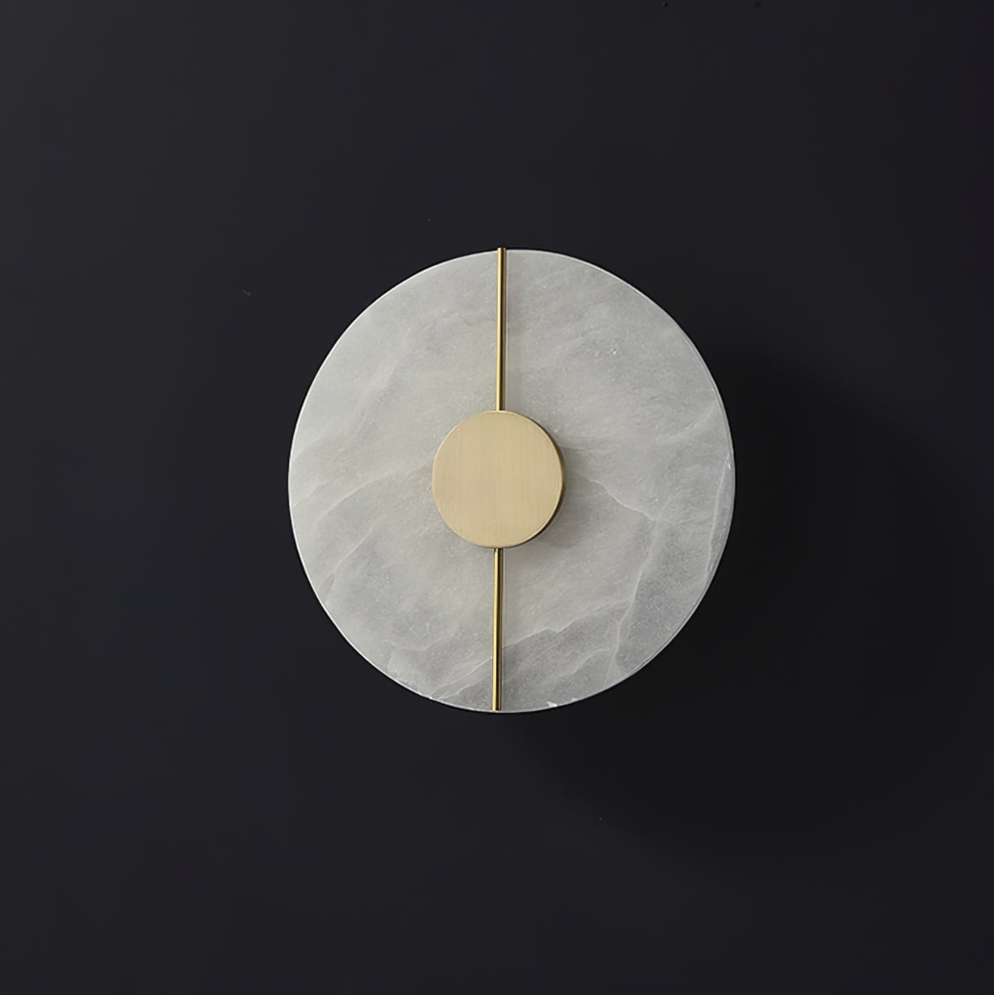Wall light with a round veined alabaster disc, a slim brass rod and a brass centre disc, unlit, on a dark background.