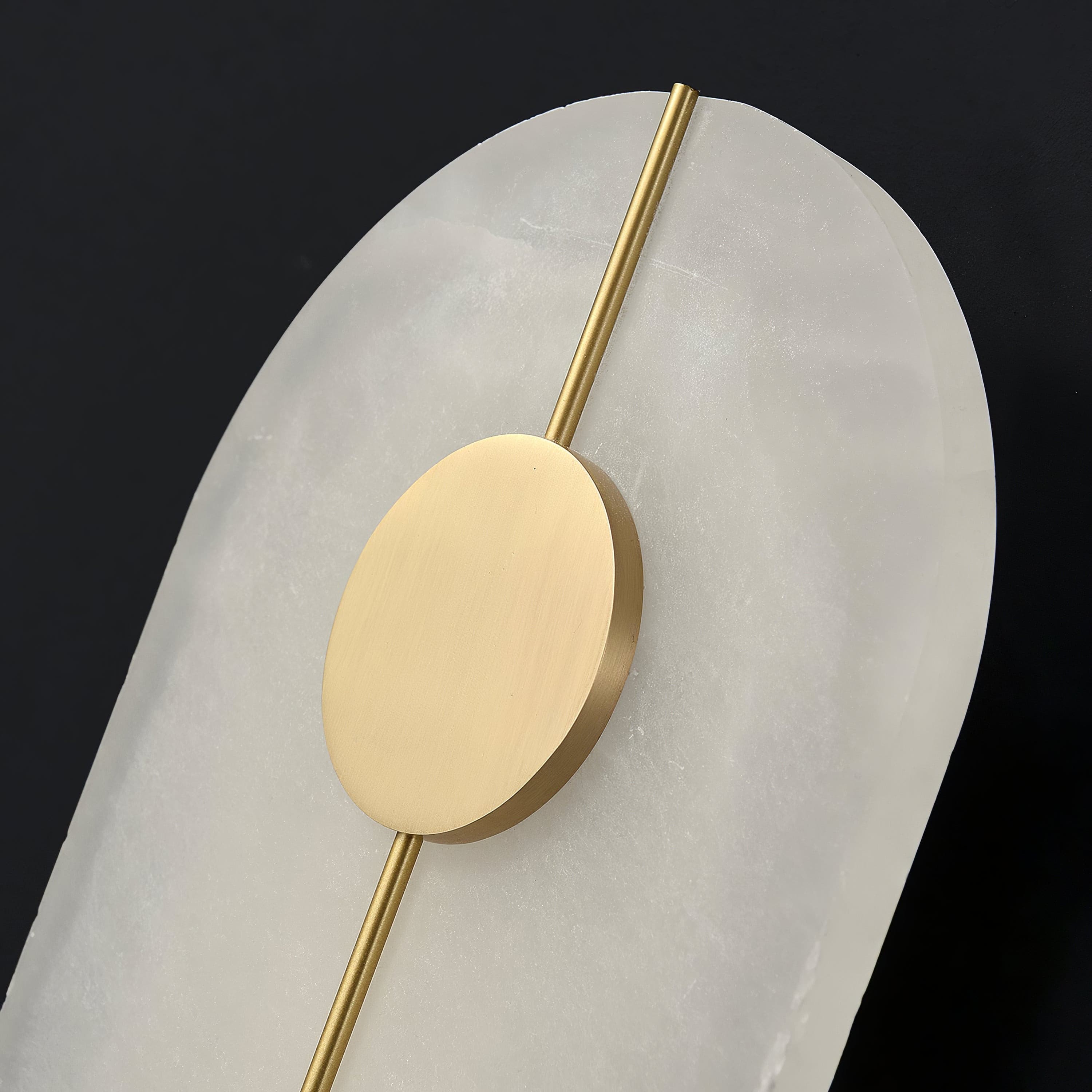 Close view of the brass disc and rod on the tall alabaster panel.
