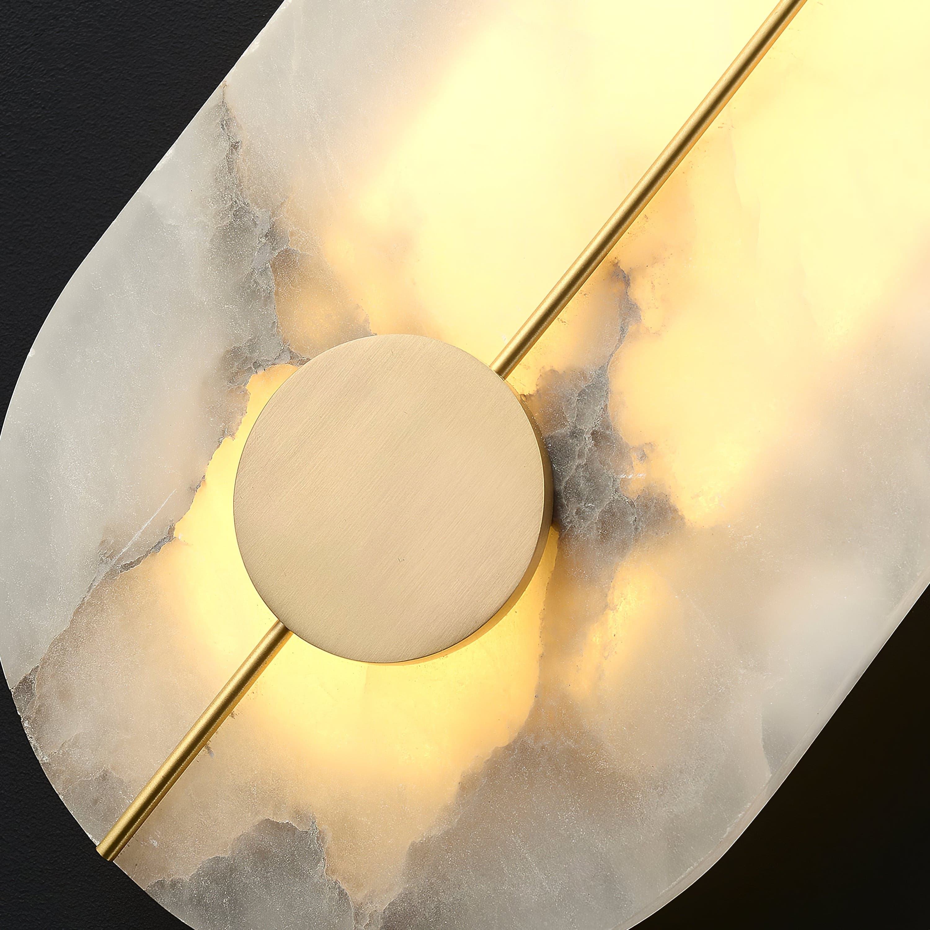 Close view of the brass disc and rod crossing the lit alabaster.