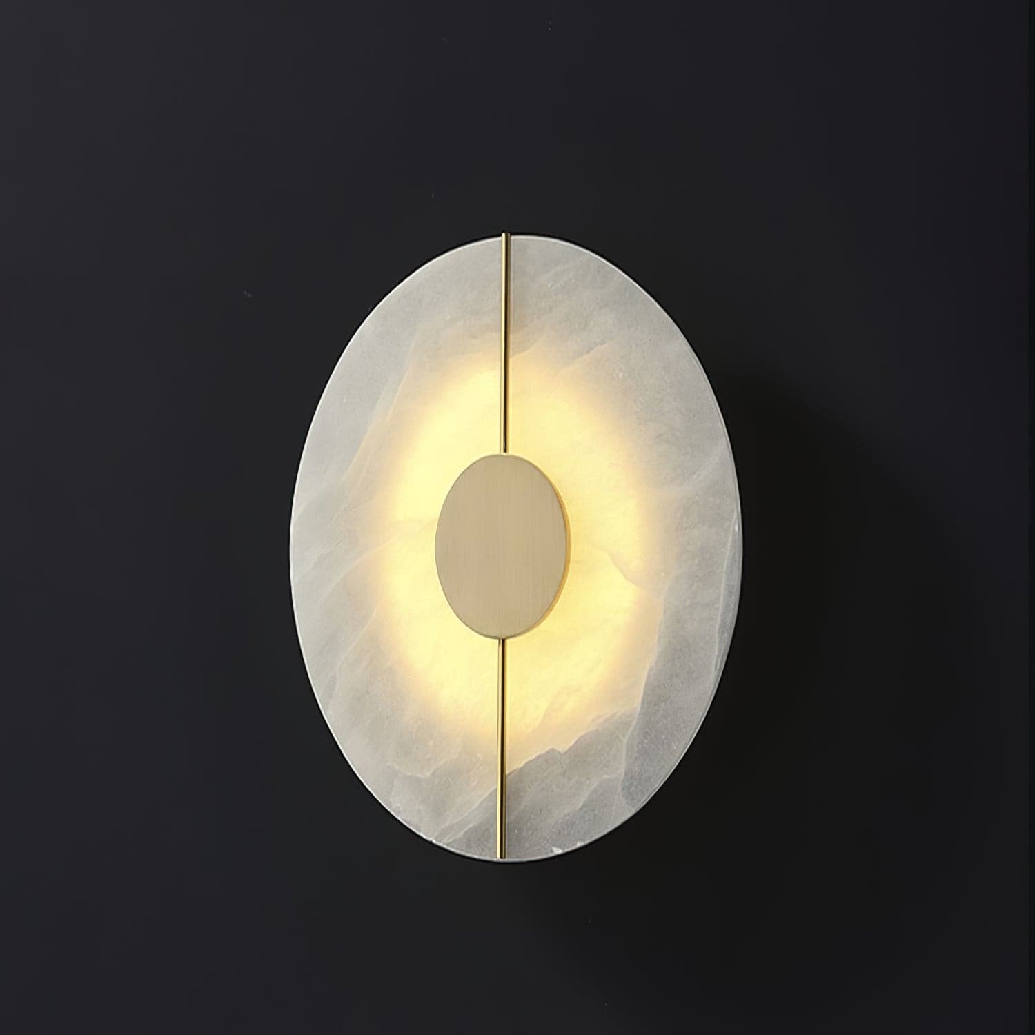Wall light with a round veined alabaster disc, a slim brass rod and a brass centre disc lit on a dark background, seen slightly turned.