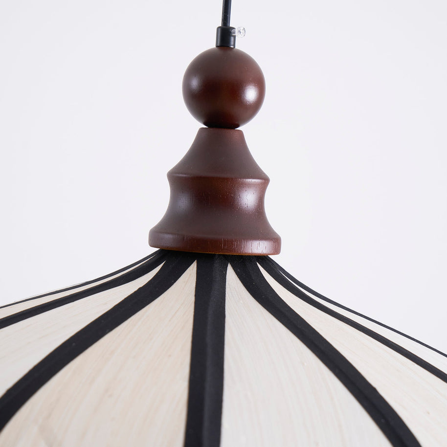 Close view of the turned walnut-coloured wooden top with the dark ribs spreading from it.