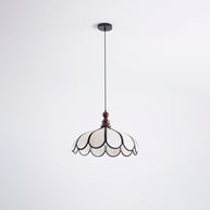 Pendant light with a scalloped beige shade, dark ribs and a turned walnut-coloured wooden top shown whole on a white background with its cord and ceiling plate.