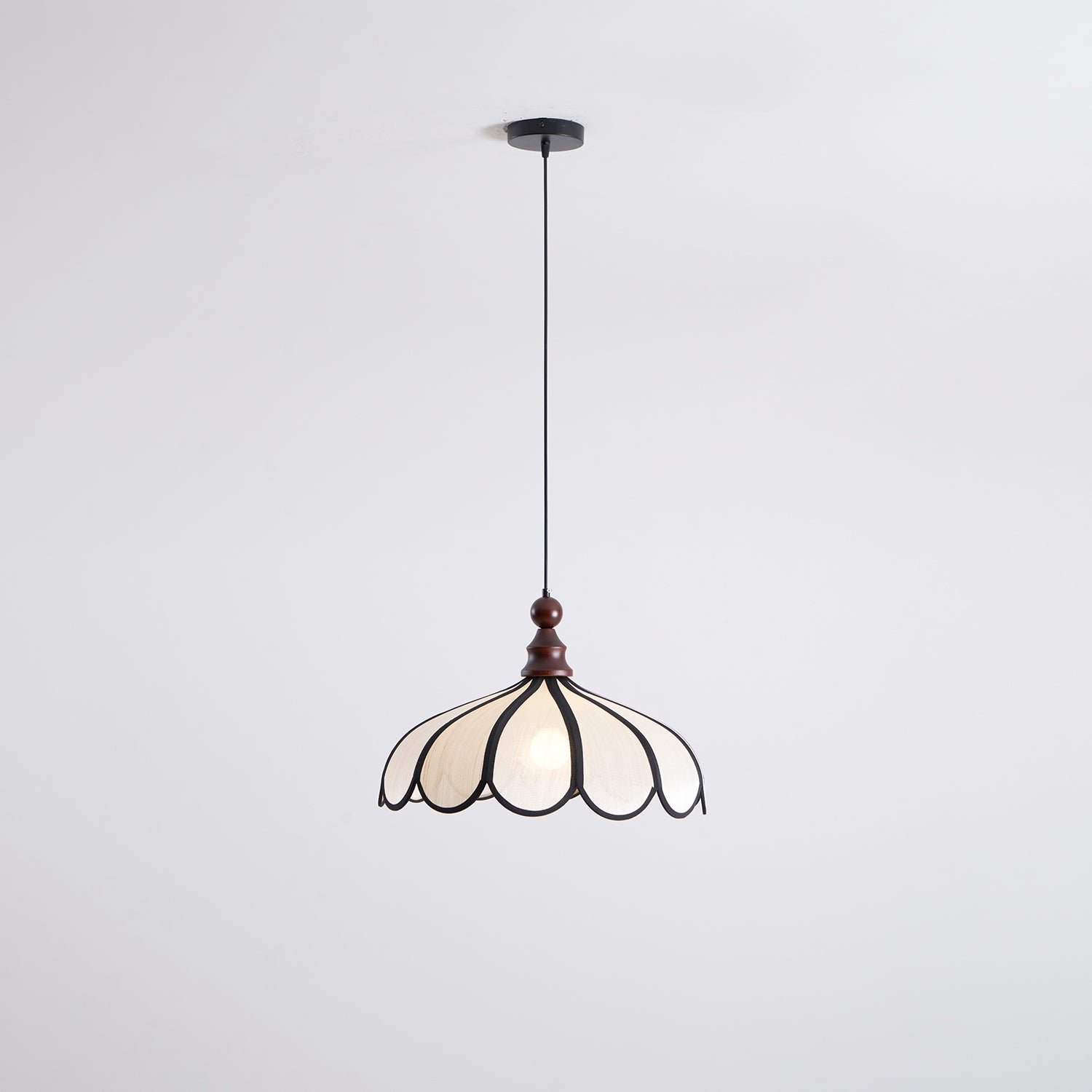 Pendant light with a scalloped beige shade, dark ribs and a turned walnut-coloured wooden top shown whole and lit on a white background.