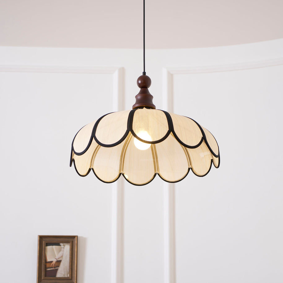 Pendant light with a scalloped beige shade, dark ribs and a turned walnut-coloured wooden top lit, seen close against a panelled wall.