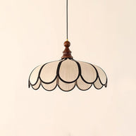 Pendant light with a scalloped beige shade, dark ribs and a turned walnut-coloured wooden top, shown on a plain background.