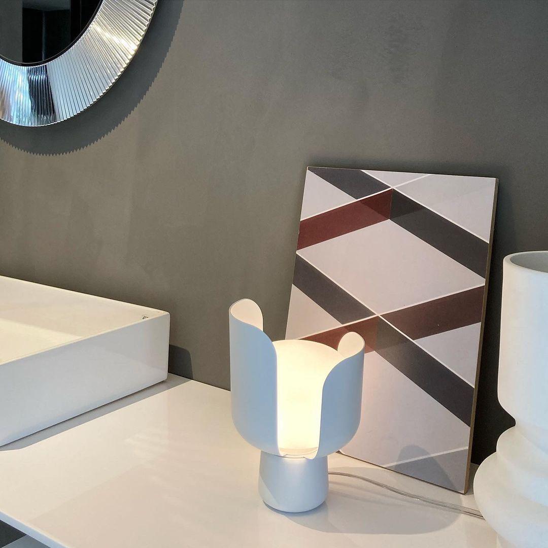 Pethella Table Lamp in white, lit beside a basin