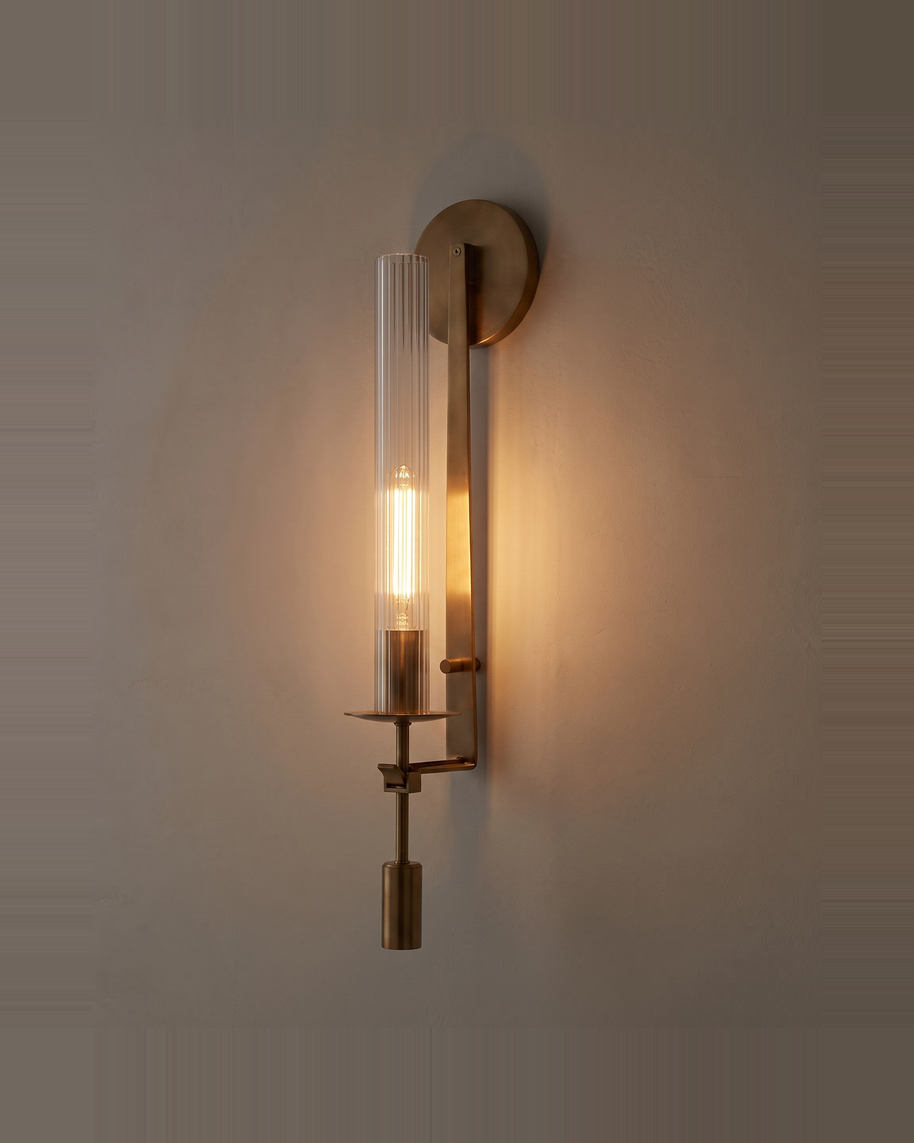 Valenne Ribbed Glass Wall Sconce lit at dusk on a warm limewash wall