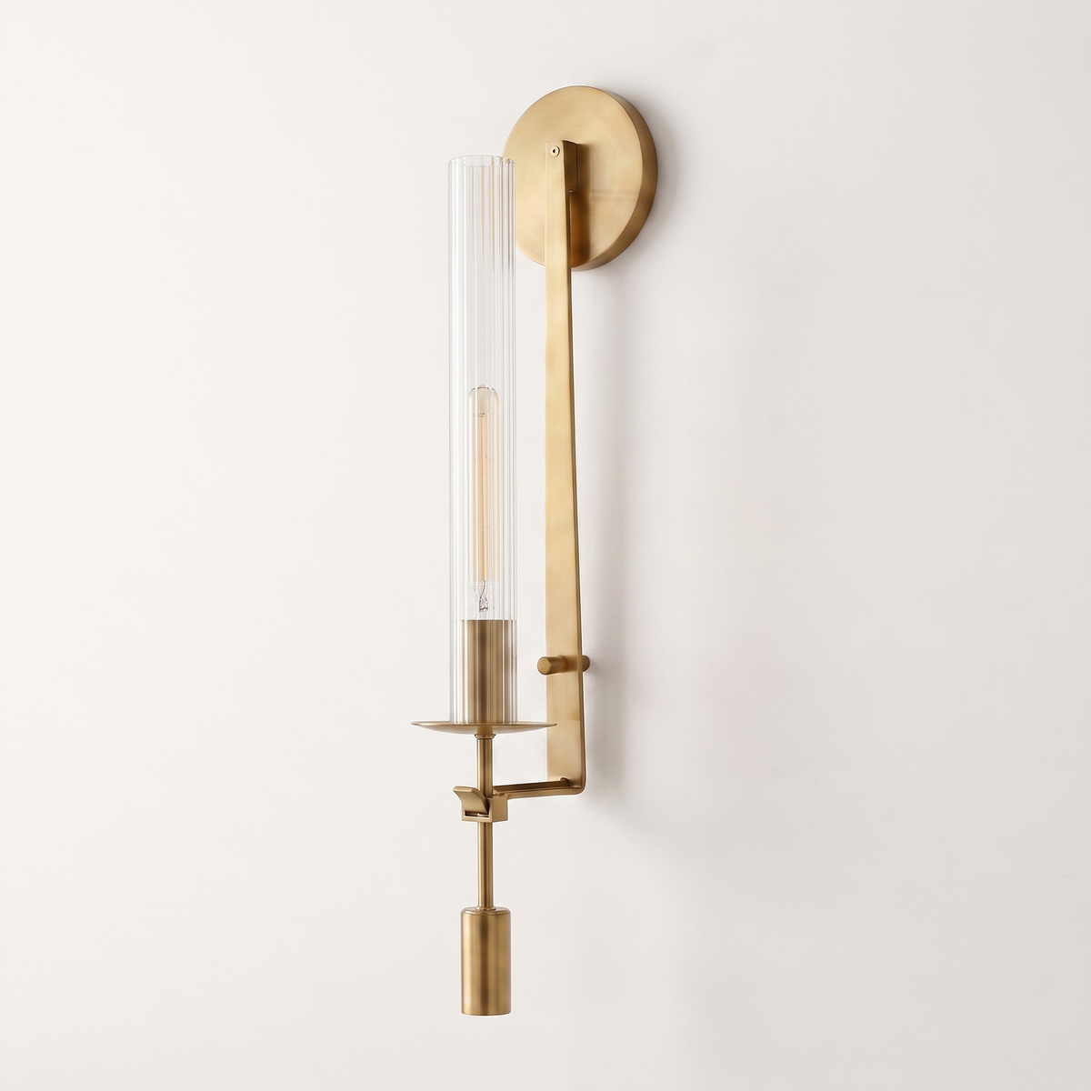 Valenne Ribbed Glass Wall Sconce, three-quarter studio view of the brass arm and ribbed glass cylinder