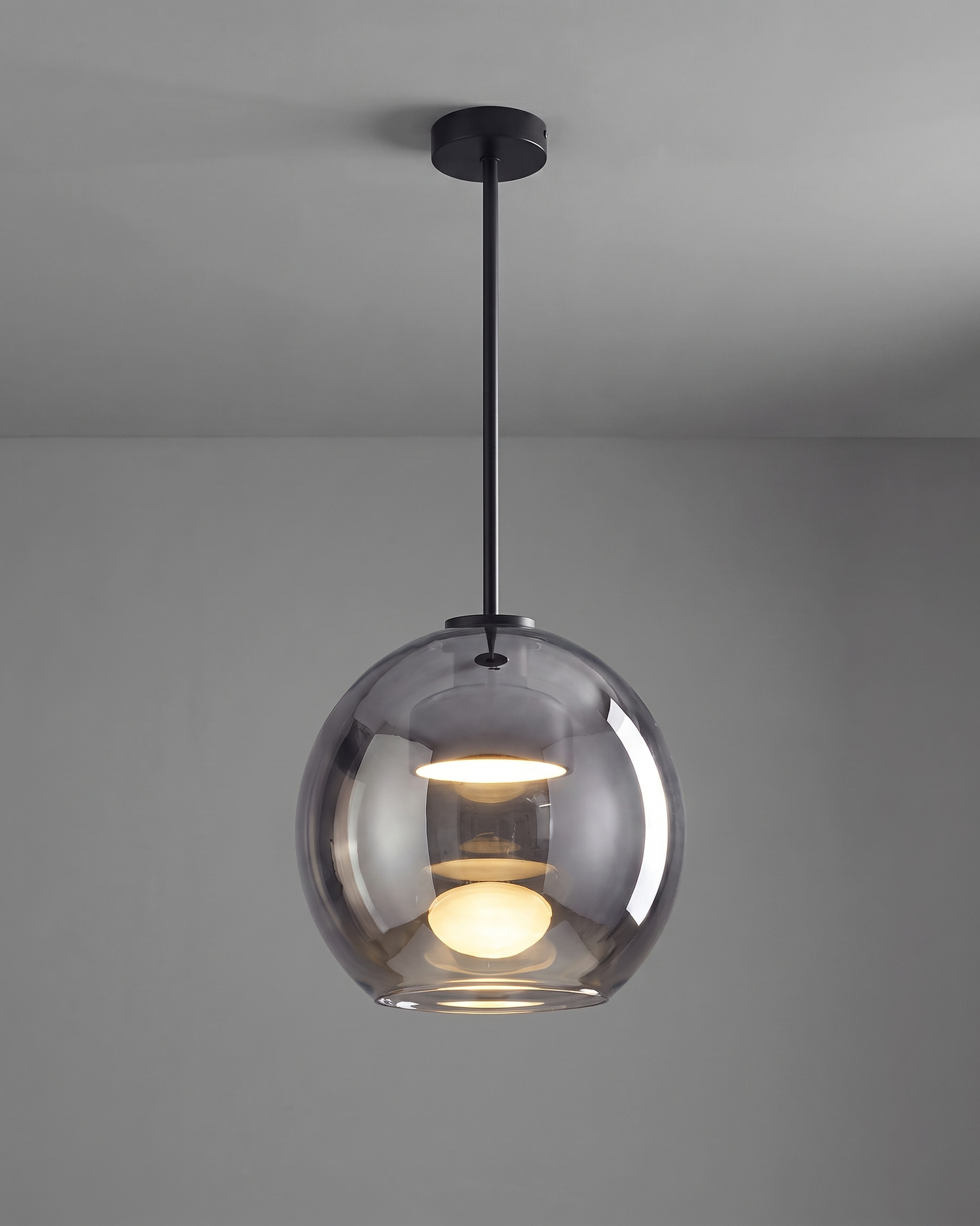 Comvilo Metro Sphere Glass Pendant Lamp in black metal and smoke-grey glass, installed, from a different vantage.