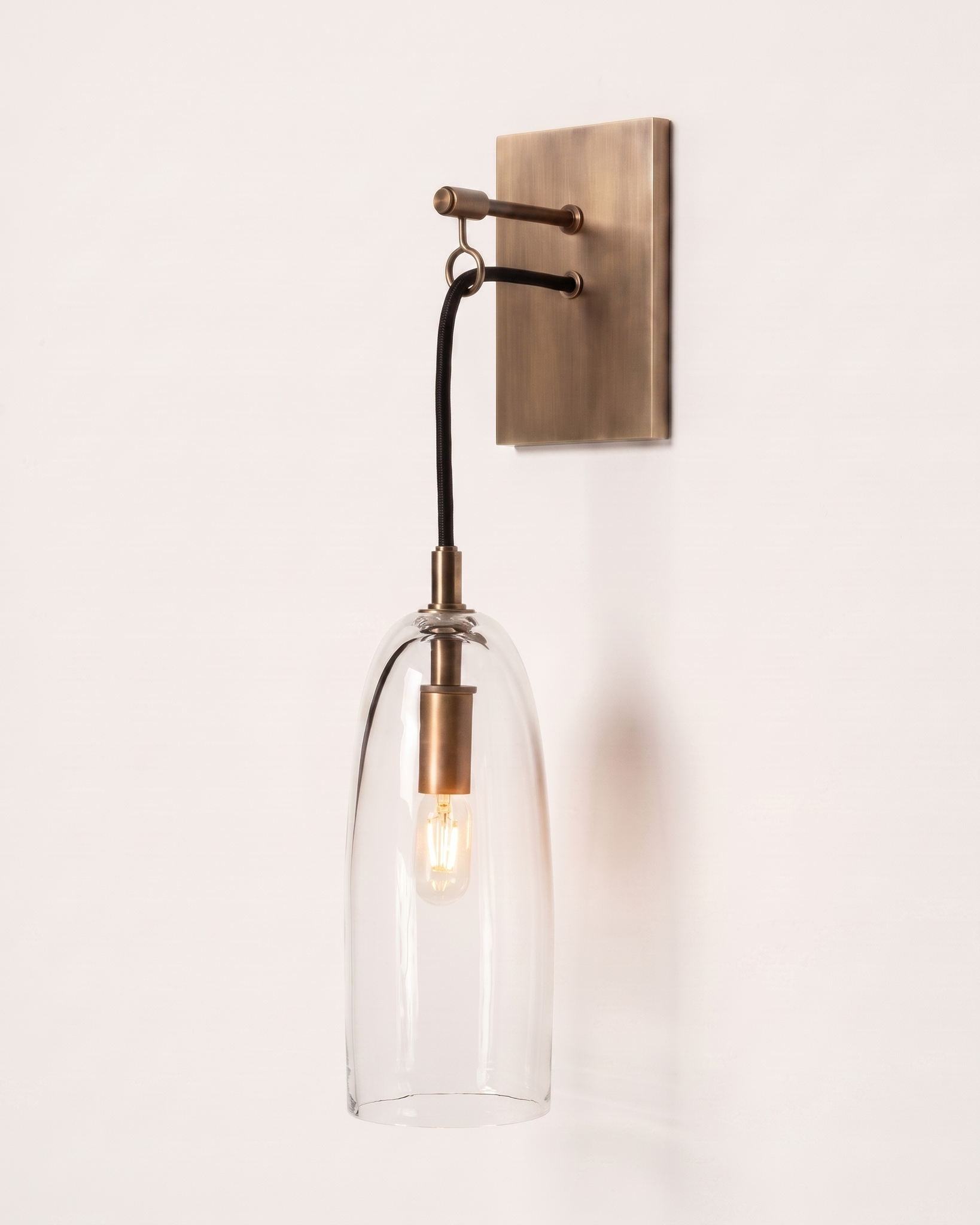 Comvilo Lure Wall Lamp in brass and clear, installed, from a different vantage.