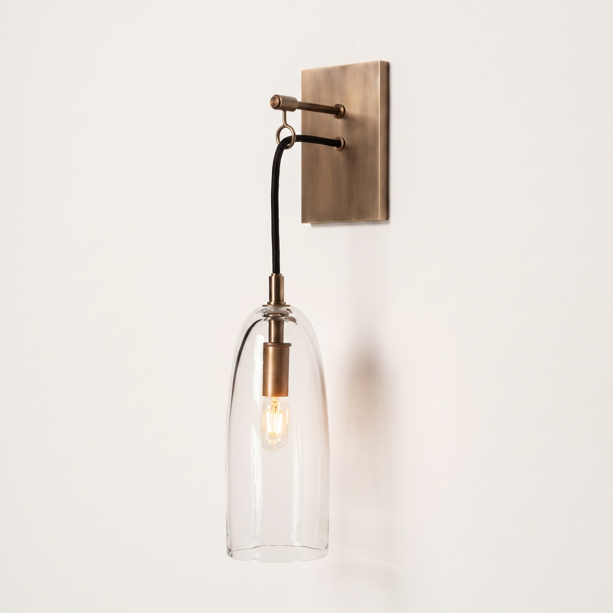 Comvilo Lure Wall Lamp in brass and clear, at a three-quarter studio angle.