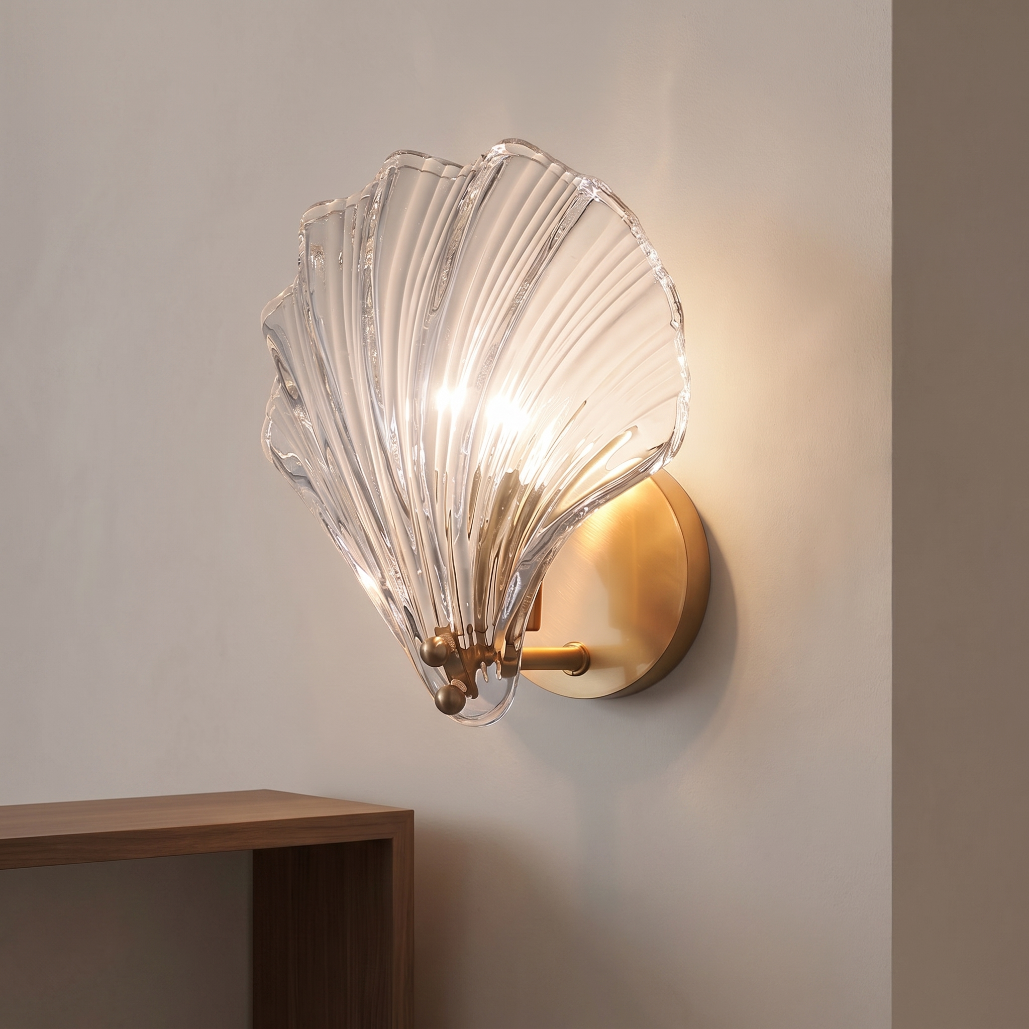 Brass shell-shaped wall light with a clear ribbed glass shade.
