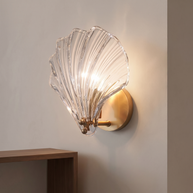 Brass shell-shaped wall light with a clear ribbed glass shade.
