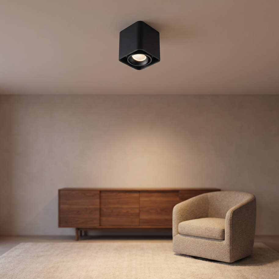 Black square adjustable ceiling spotlight in a neutral living room.