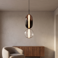 Two-globe pendant light with smoked and clear glass shades.
