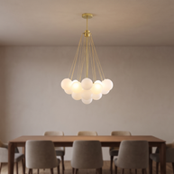 Gold chandelier with clustered white glass globes above a dining table.
