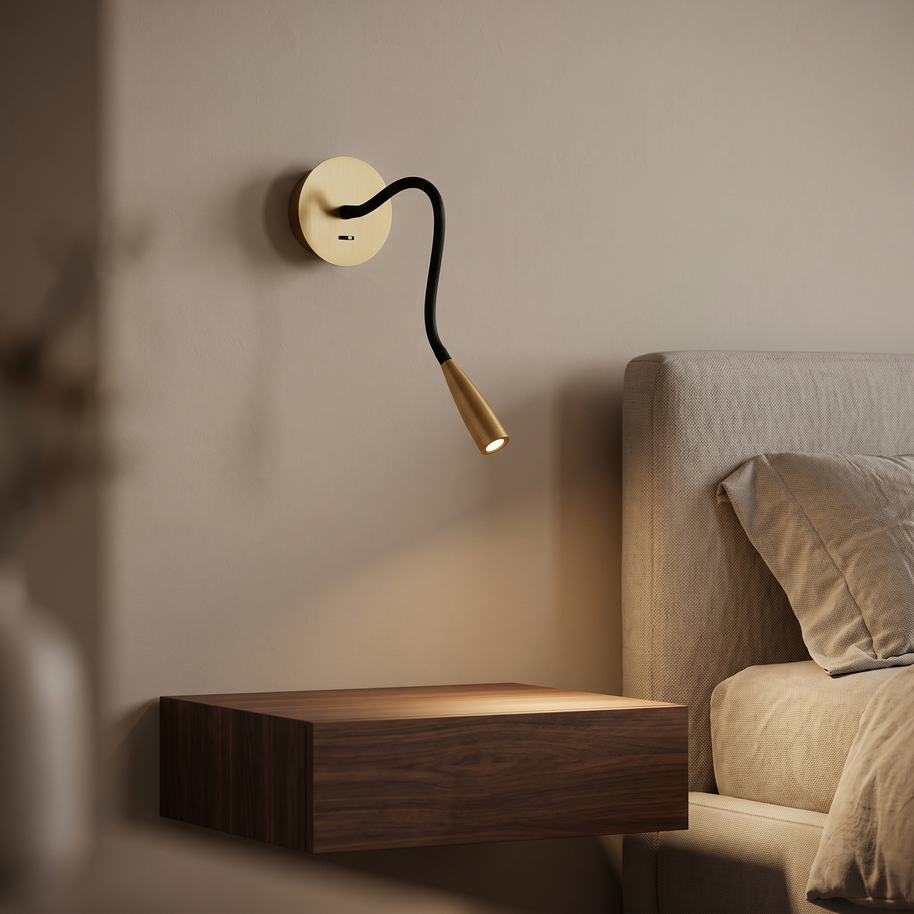 Brass and black flexible wall reading light beside a bed.