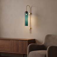Gold wall light with a long green glass shade.