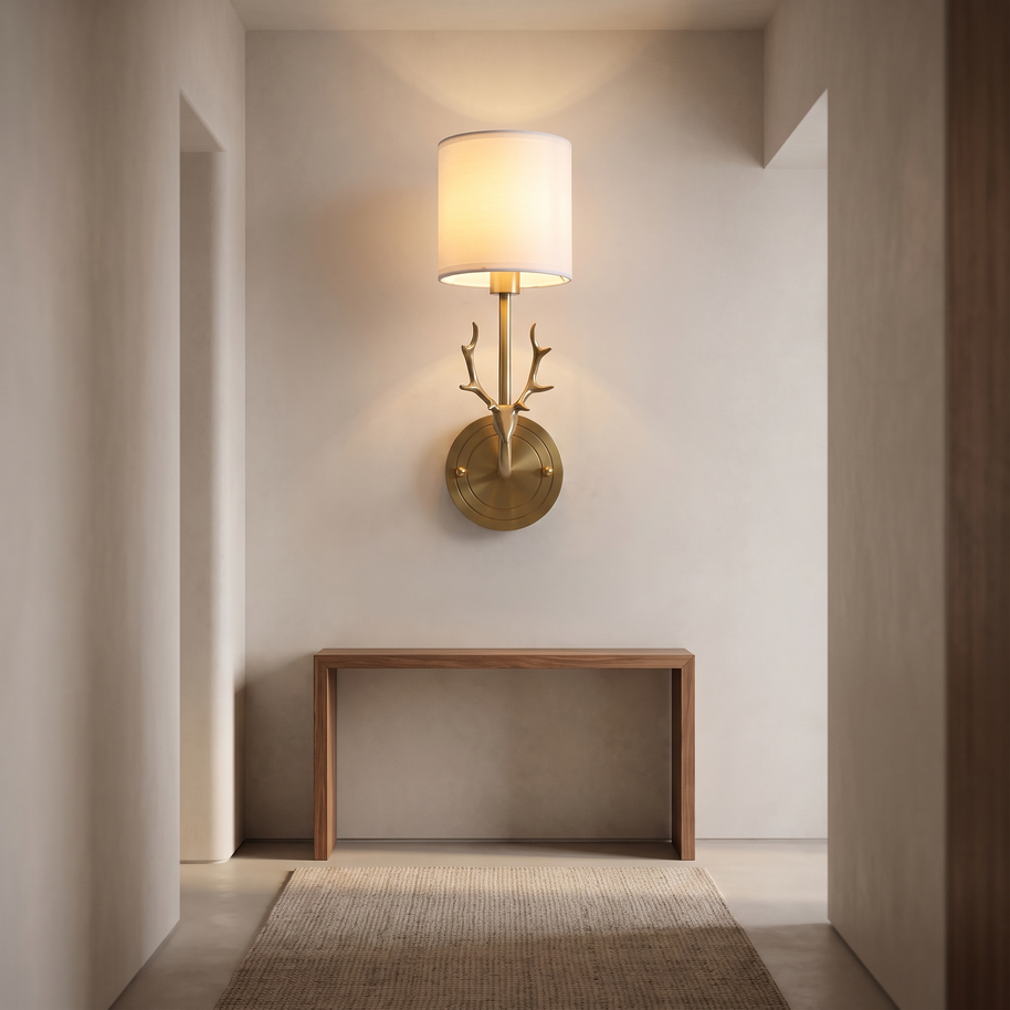 Brass deer head wall light with a white fabric shade.