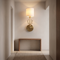 Brass deer head wall light with a white fabric shade.