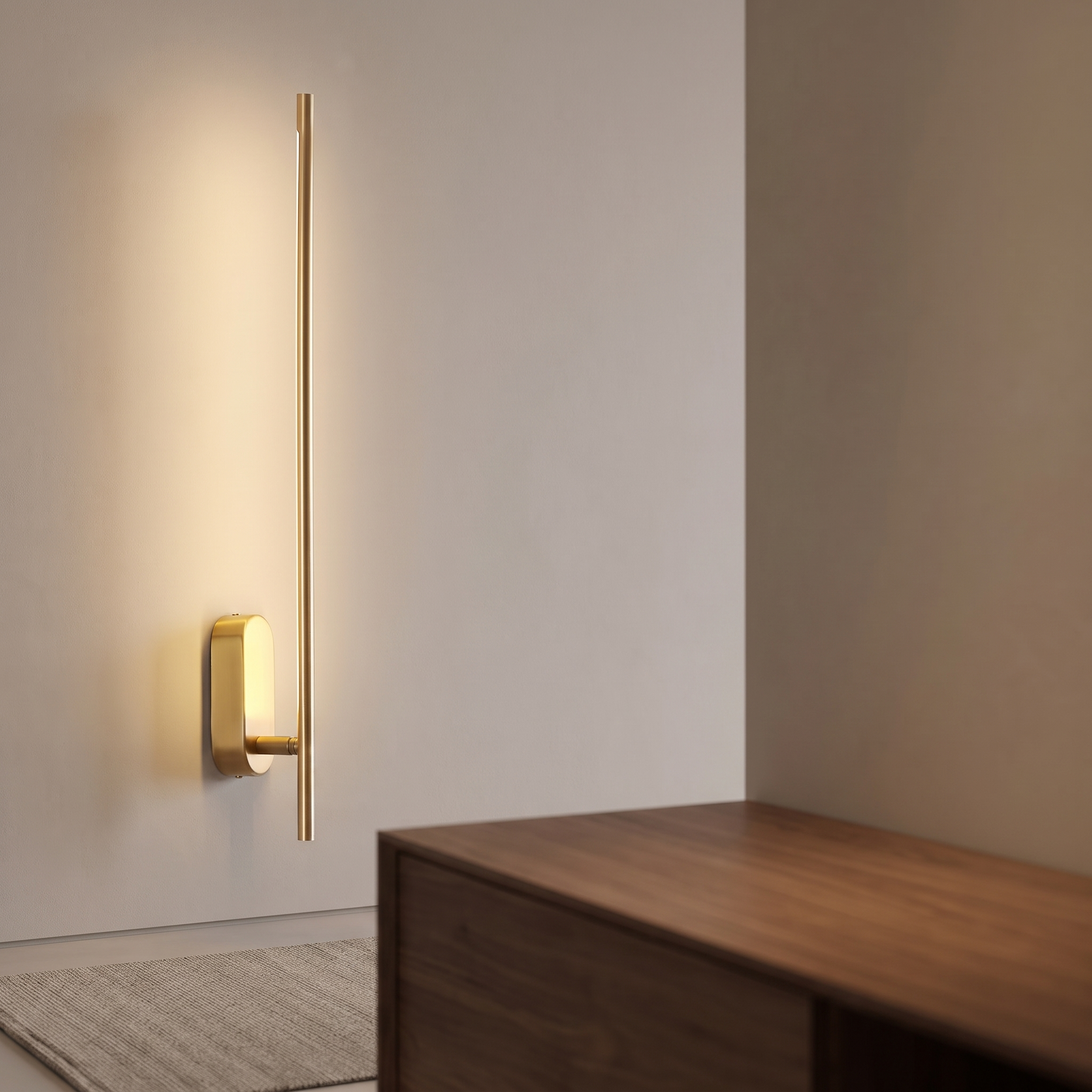 Slim brass vertical wall sconce casting warm light.