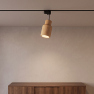 Natural wood track spotlight on a black ceiling rail.