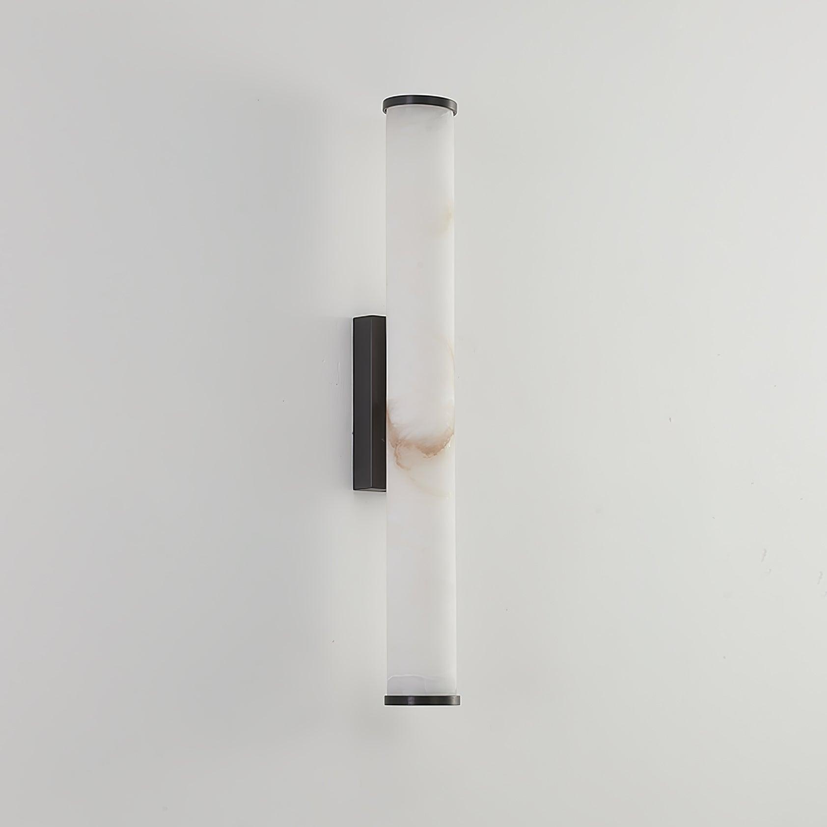 Wall lamp with a long pale veined alabaster tube and a black bracket, unlit, on a white wall.