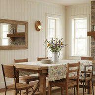 Wall lamp with a shaped walnut-coloured wooden backplate and a white glass globe on a boarded wall in a dining room.