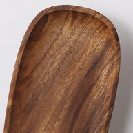 Close view of the wooden backplate showing its grain and shaped edge.