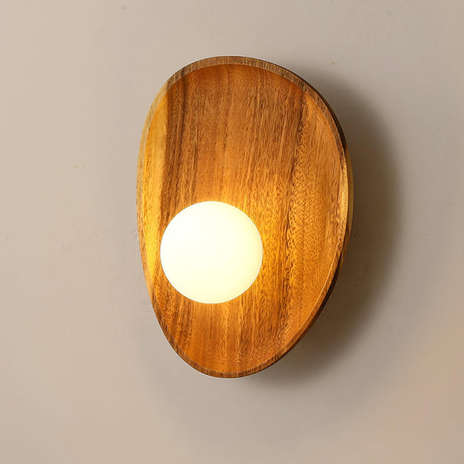 Wall lamp with a shaped walnut-coloured wooden backplate and a white glass globe lit, wider oval shape, shown large on a plain wall.