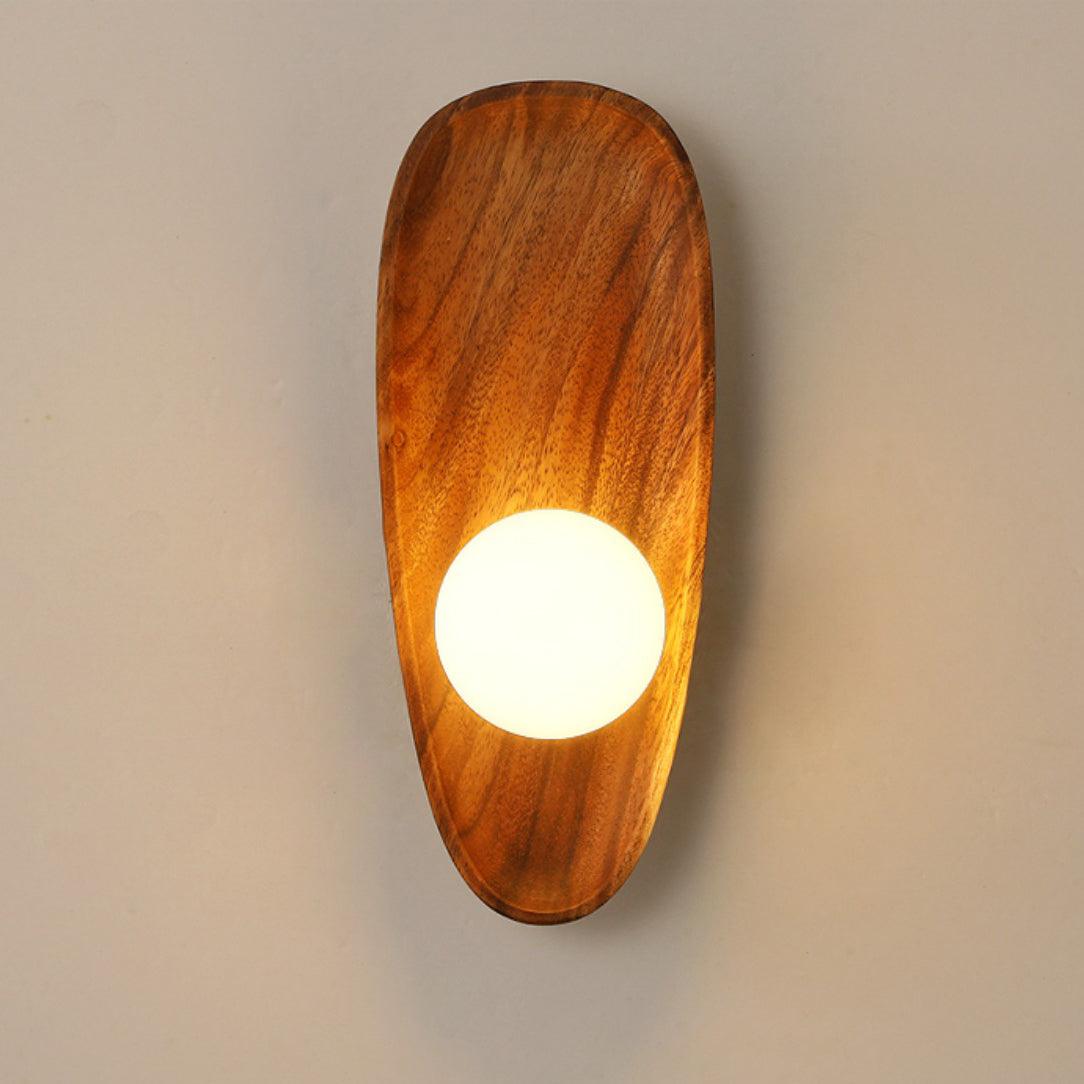 Wall lamp with a shaped walnut-coloured wooden backplate and a white glass globe lit, narrow upright shape, shown large on a plain wall.