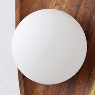 Close view of the white glass globe against the wooden backplate.