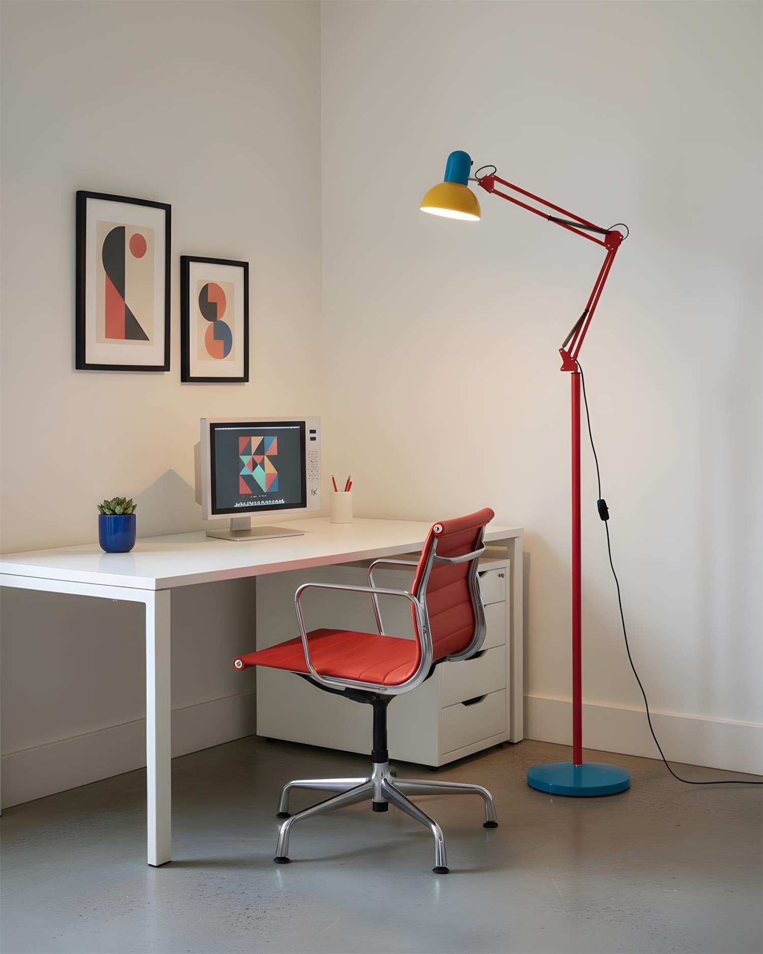 Adjustable floor lamp with a red arm, yellow shade and round blue base beside a white desk and a red office chair.
