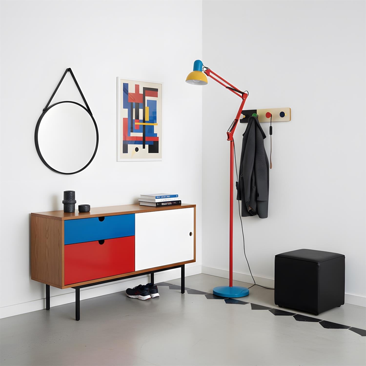 Adjustable floor lamp with a red arm, yellow shade and round blue base in a hallway beside a sideboard and a round mirror.