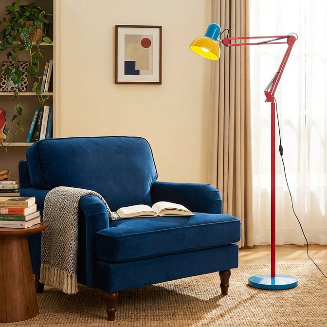 Adjustable floor lamp with a red arm, yellow shade and round blue base beside a blue armchair holding an open book.