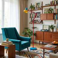 Adjustable floor lamp with a red arm, yellow shade and round blue base in a living room, with the base width marked as 28cm.