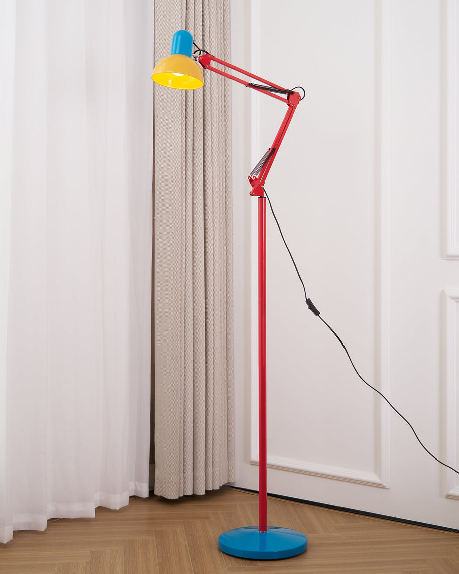 Adjustable floor lamp with a red arm, yellow shade and round blue base beside a white curtain and door.
