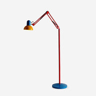 Adjustable floor lamp with a red arm, yellow shade and round blue base, arm raised, shown on a plain background.