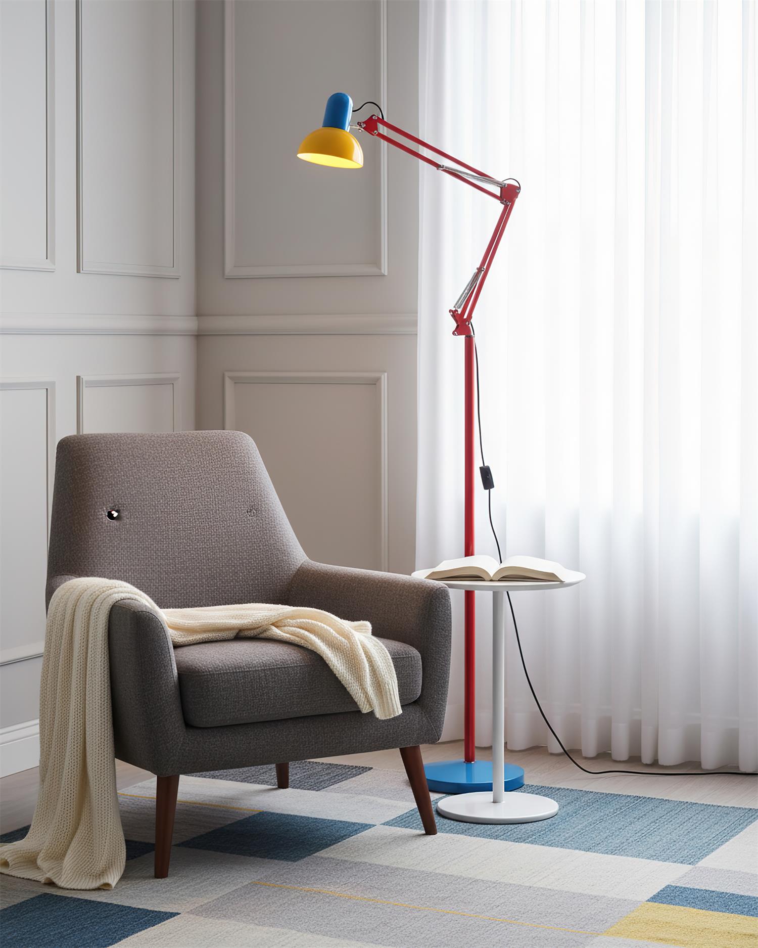 Adjustable floor lamp with a red arm, yellow shade and round blue base beside a grey armchair with a throw.