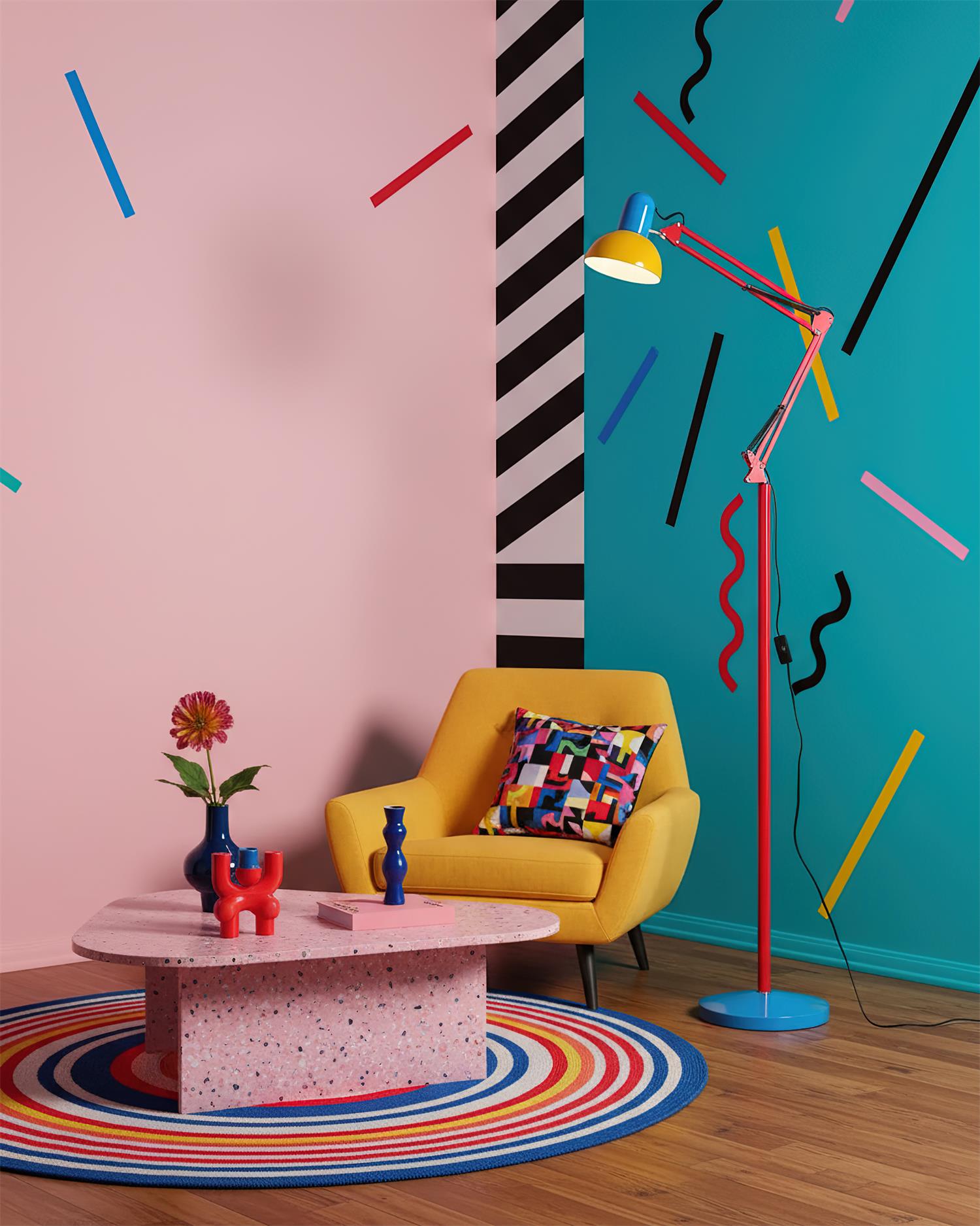 Adjustable floor lamp with a red arm, yellow shade and round blue base in a living area with a yellow armchair against pink and teal walls.