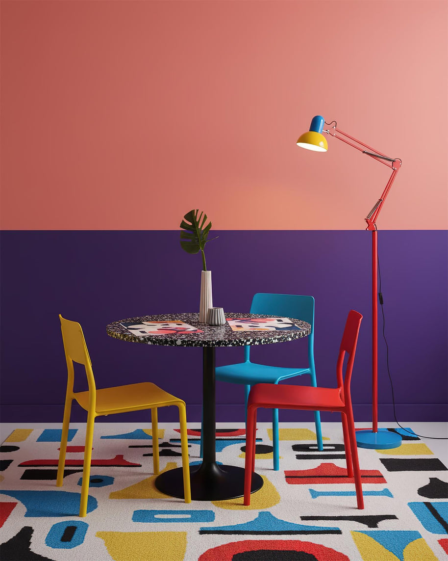 Adjustable floor lamp with a red arm, yellow shade and round blue base beside a dining table in a room with pink and purple walls.