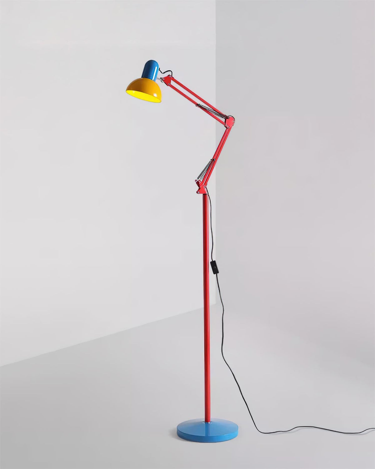 Adjustable floor lamp with a red arm, yellow shade and round blue base shown full length on a plain background.