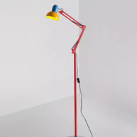 Adjustable floor lamp with a red arm, yellow shade and round blue base shown full length on a plain background.