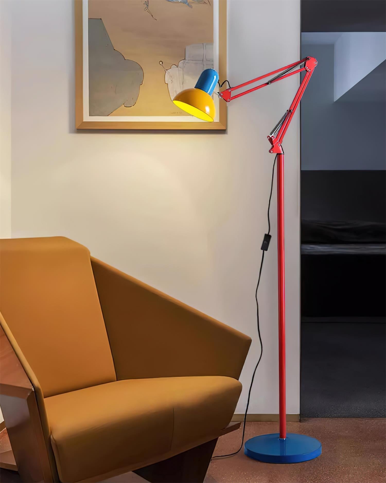 Adjustable floor lamp with a red arm, yellow shade and round blue base lit beside a mustard chair near a doorway.